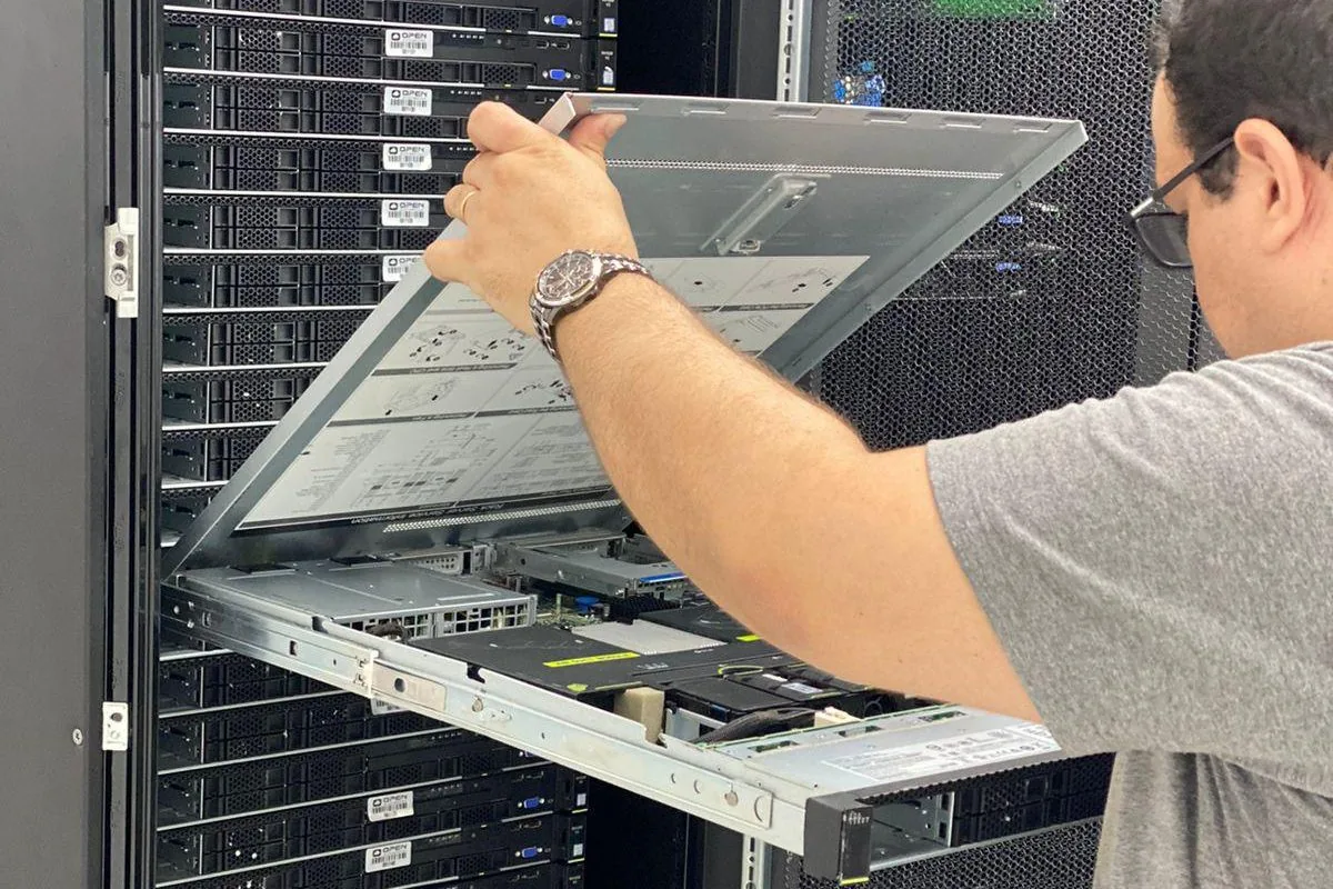 Técnico da OPEN abrindo um servidor no rack do datacenter